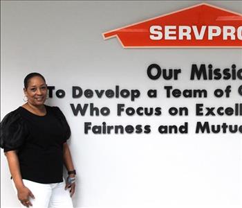 Tech standing in front of our mission statement