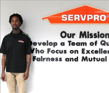 Tech standing in front of our mission statement