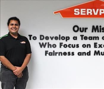 Tech standing in front of our mission statement