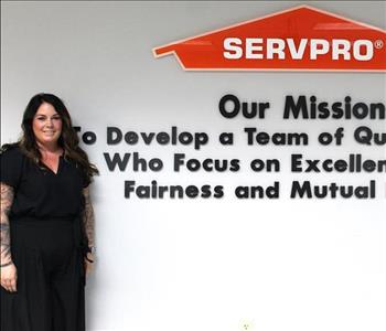 Tech standing in front of our mission statement