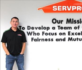 Tech standing in front of our mission statement